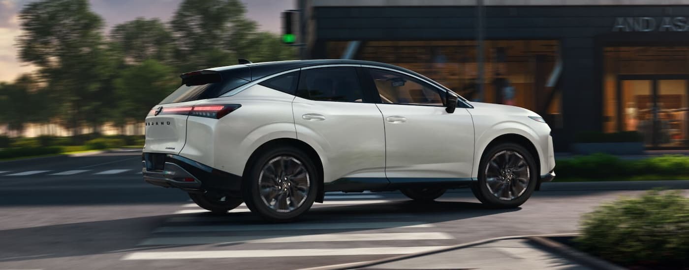 White 2026 Nissan Murano driving down a city street.