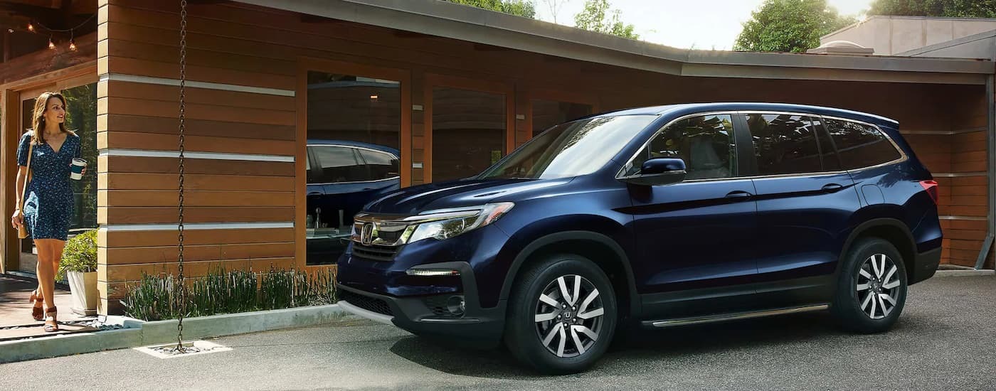 A blue 2022 Honda Pilot parked in a driveway.