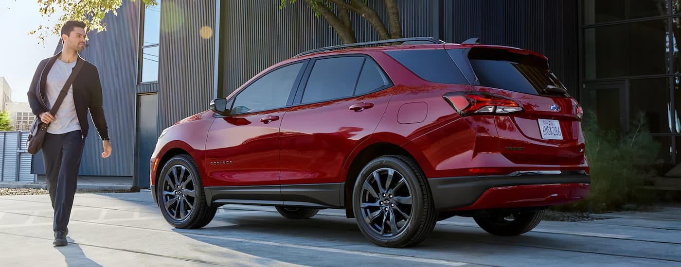 A red 2022 Chevy Equinox RS is parked on the side of a city street.