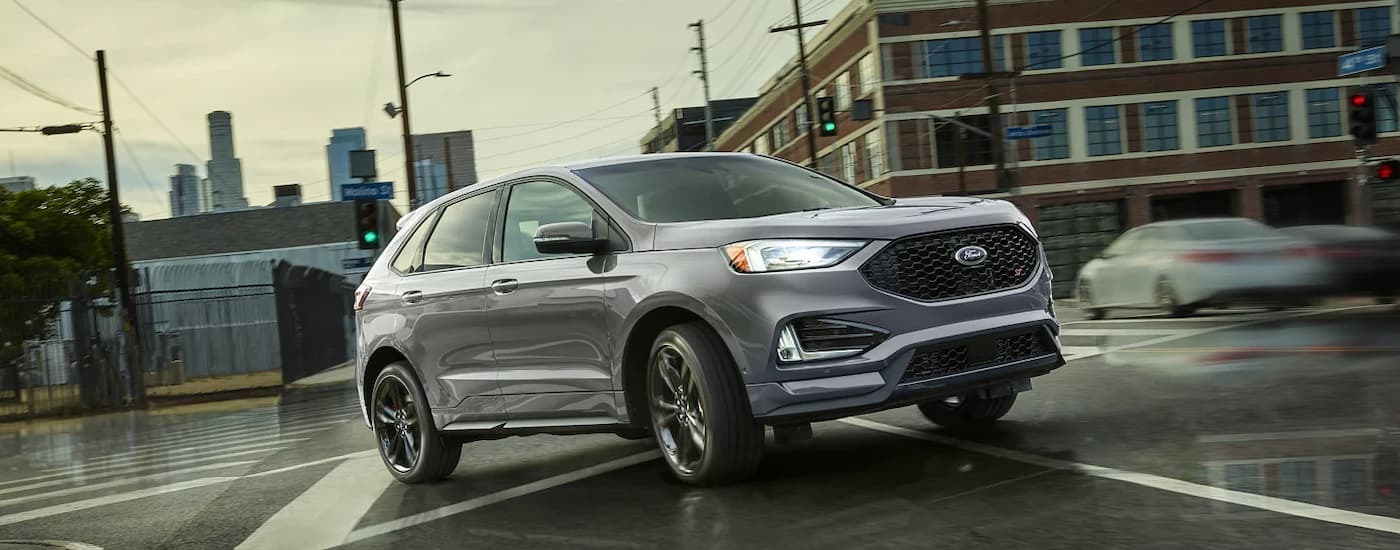 Silver 2022 Ford Edge ST driving on a city street to view used SUVs for sale near Union City.