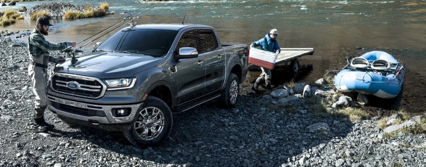 Grey 2023 Ford Maverick parked near a river as people prepare to fish