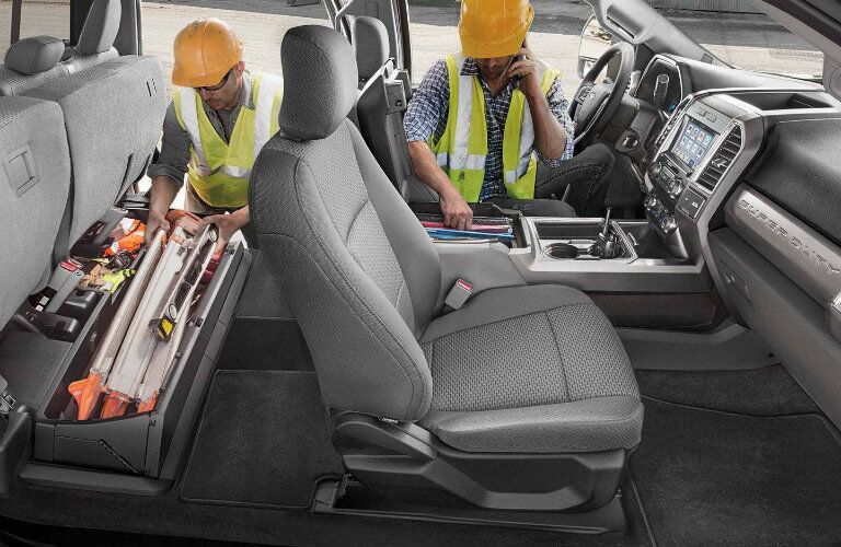 Two workers using cargo management system inside 2019 Ford Super Duty F-350 Platinum