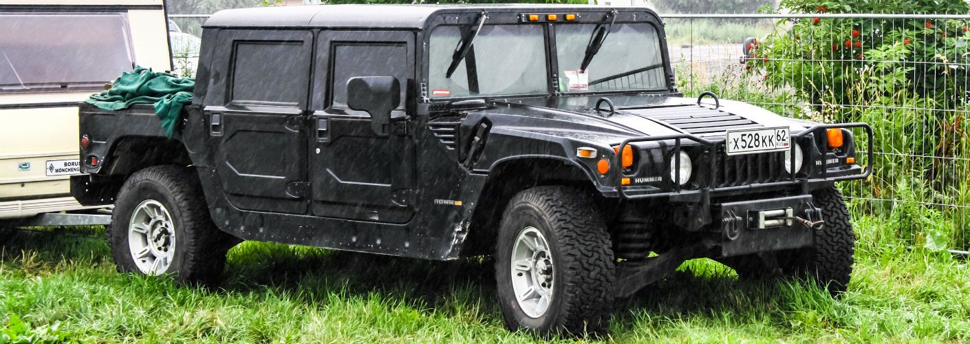Hummer Parked in Field Towing Trailer