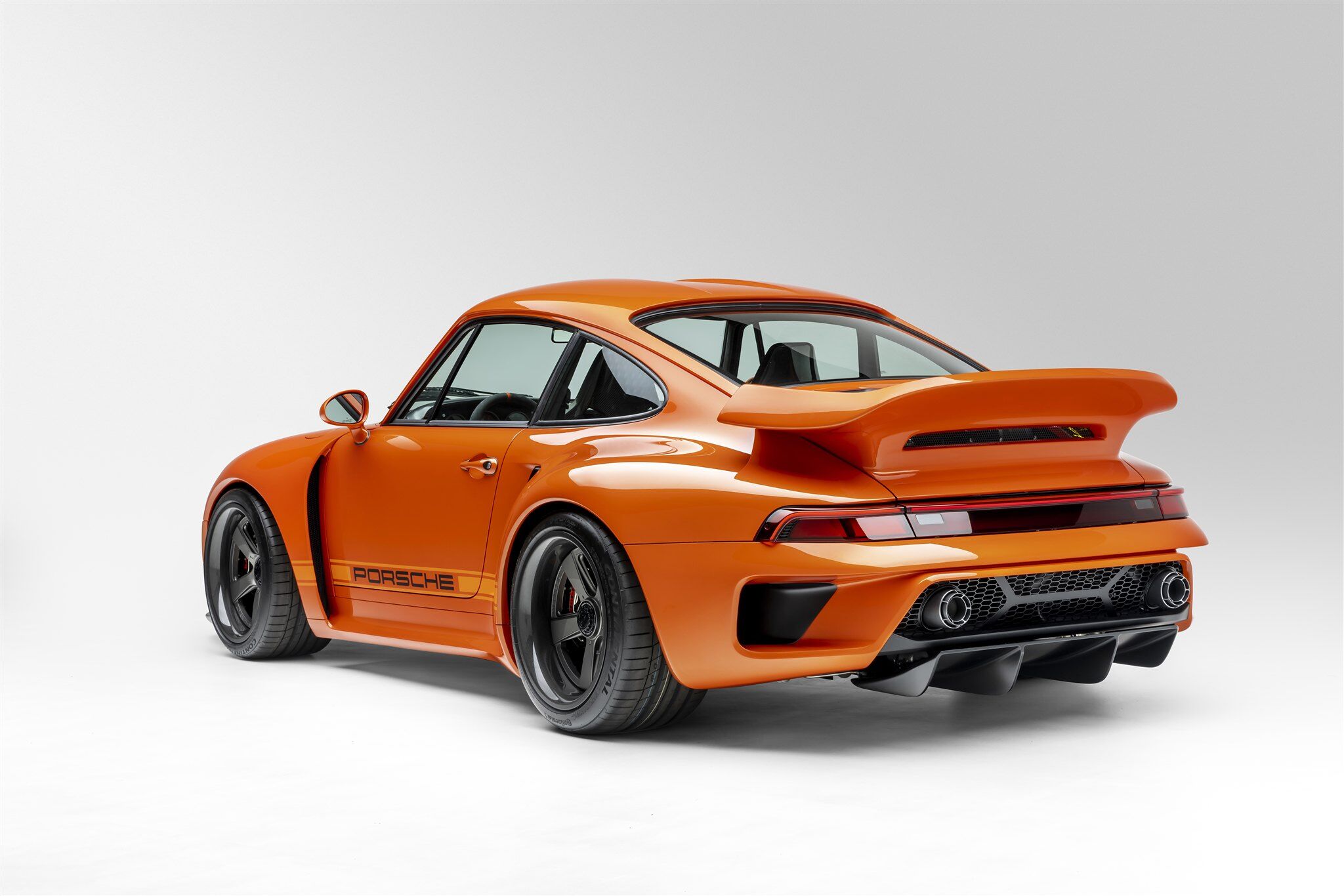 Porsche Turbo model with orange paint rear and side angle on white