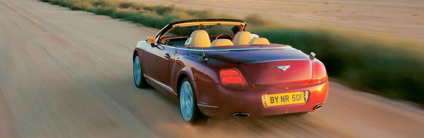 red bentley convertible on dirt road