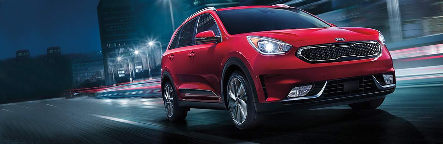 2018 Kia Niro red driving in a city at night