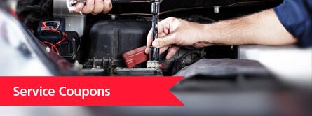 Service coupons with mechanic working on a car battery