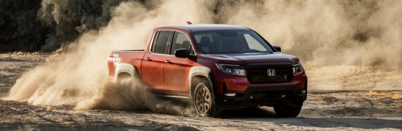 2022 Honda Ridgeline Red driving through a dusty road