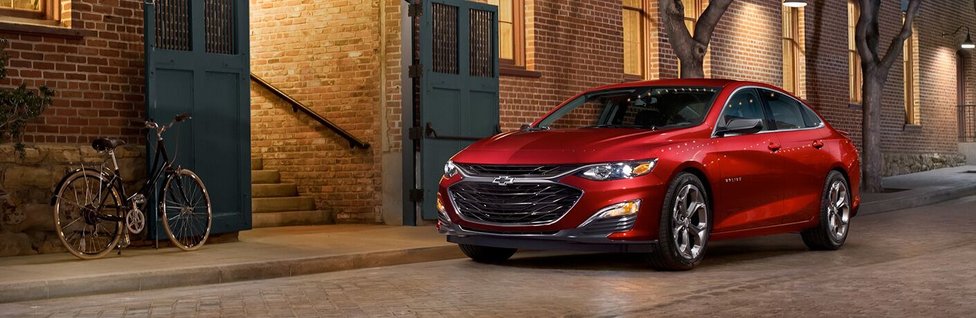 red 2019 Chevrolet Malibu parked in front of apartments