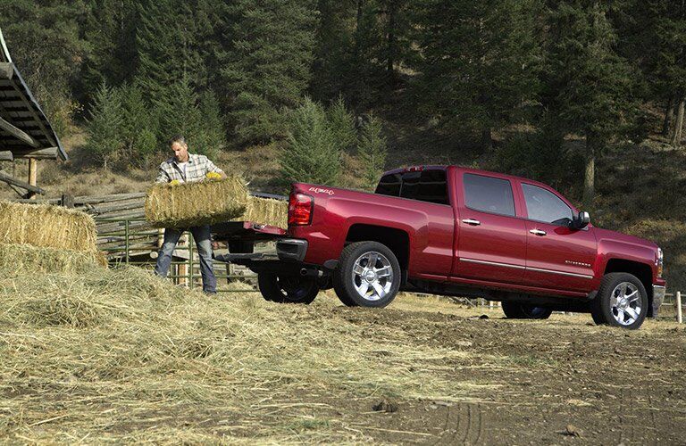side view of the 2016 Chevy Silverado being loaded with hay or straw