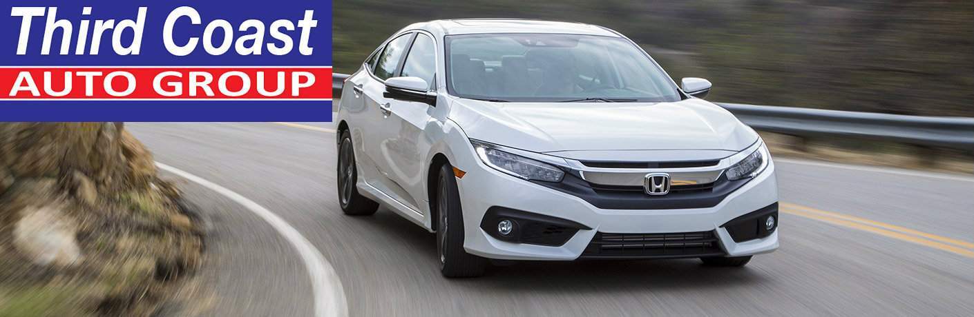 white 2017 Honda Civic sedan driving on a curved road with a Third Coast Auto Group logo in the upper left corner