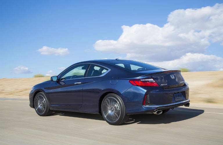 2017 Honda Accord coupe seen from the side in dark blue against a pale blue sky