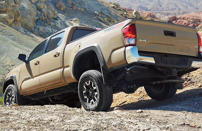 rear view of a brown 2017 Toyota Tacoma in the rocks