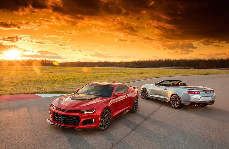 coupe and convertible versions of the 2017 Chevy Camaro against a gorgeous sunset