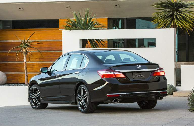 Black 2017 Honda Accord Sedan parked in front of a house with palm trees.