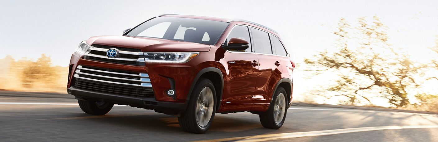 A used Toyota Highlander Hybrid on the road.