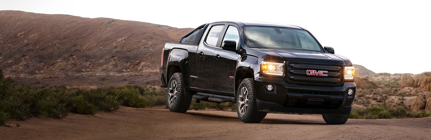 A front-end photo of a used GMC Canyon parked in the desert.