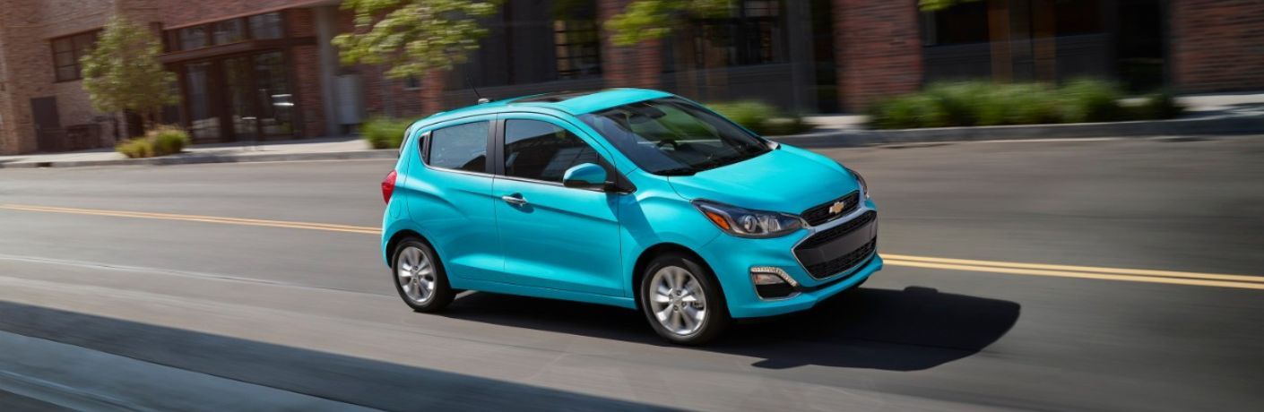 Used 2021 Chevy Spark Blue driving on the road