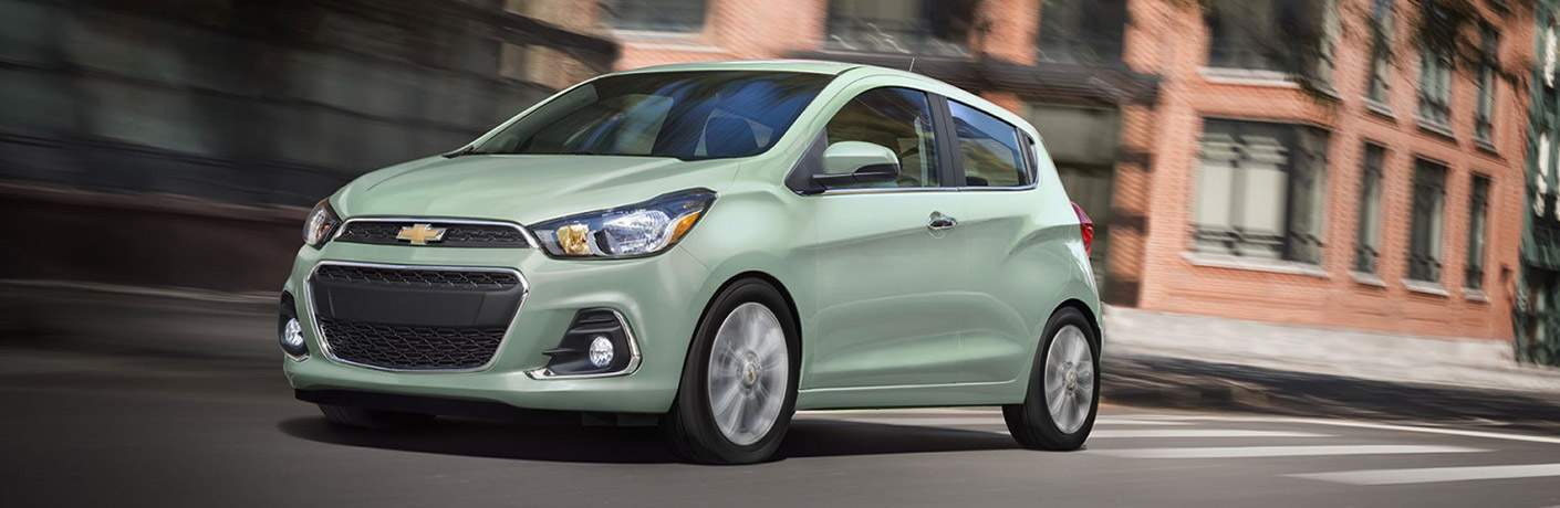 Mint green Chevy Spark driving down the road