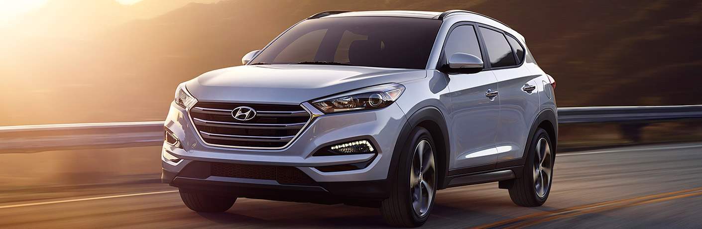 Hyundai Tucson driving over a bridge at sunset