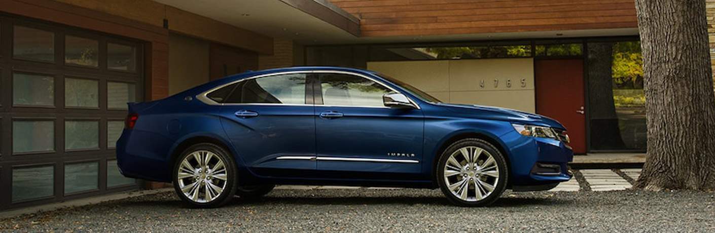 Blue Chevy Impala parked in a driveway
