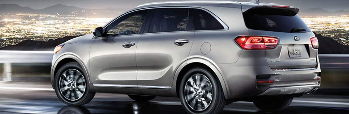 2018 Kia Sorento driving at night on a hill overlooking a large city