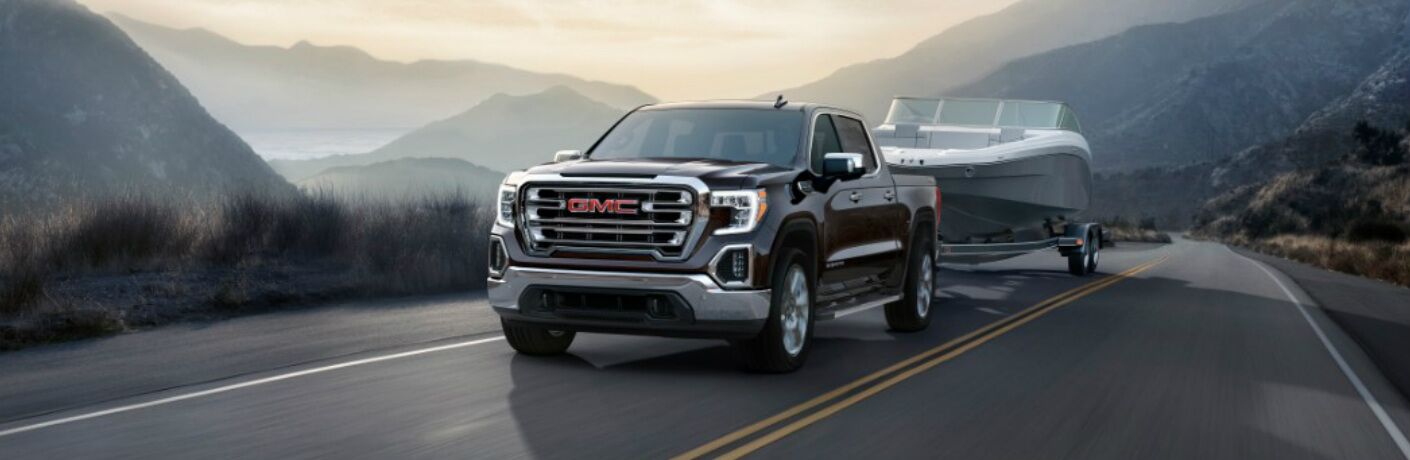 2019 GMC Sierra driving in the mountains while hauling a speed boat