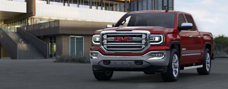 GMC Sierra 1500 parked in front of a modern building