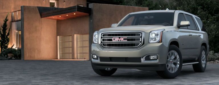 GMC Yukon parked near a modern house