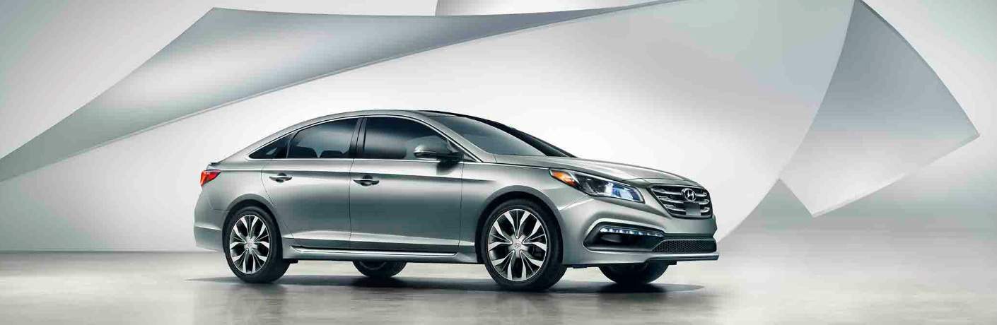 Grey Hyundai sedan parked in front of a grey geometric background