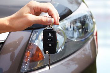 car-keys-held-in-front-of-a-headlight