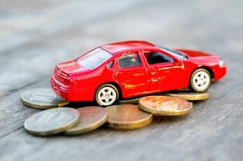 toy car sitting atop a pile of coins