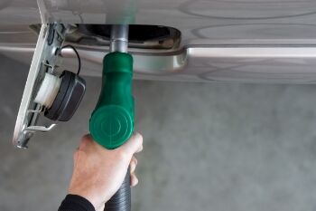 a man's hand hold a gas pump a car's tank