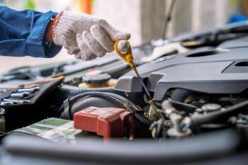 closeup photo of a mechanic pulling the dipstick from a car engine