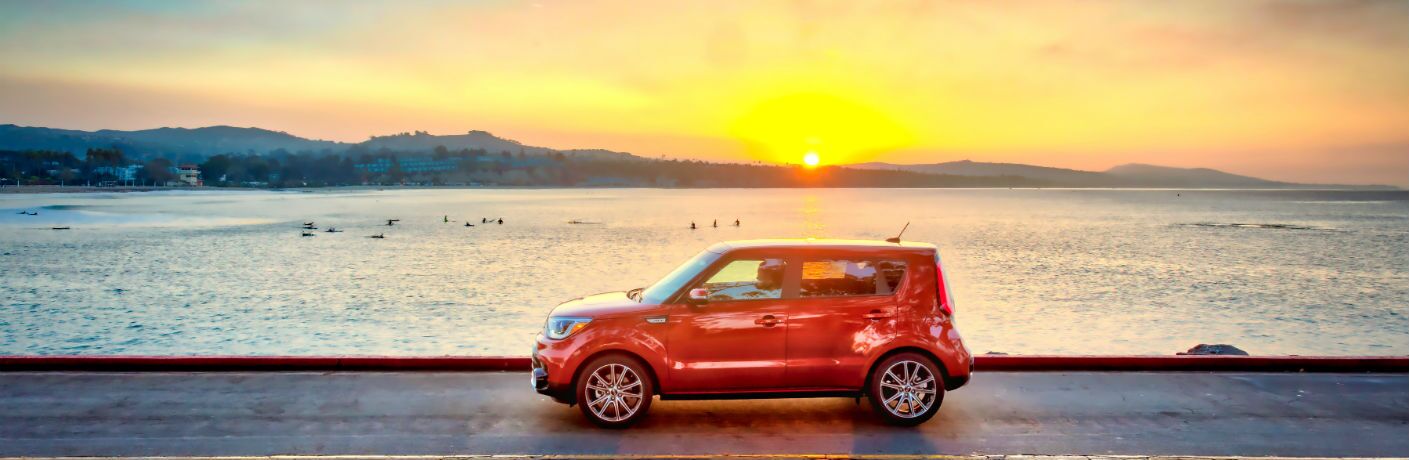 2019 Kia Soul driving by water with a sunset