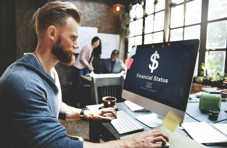 Hipster Guy Looking at Financial Information on a Computer