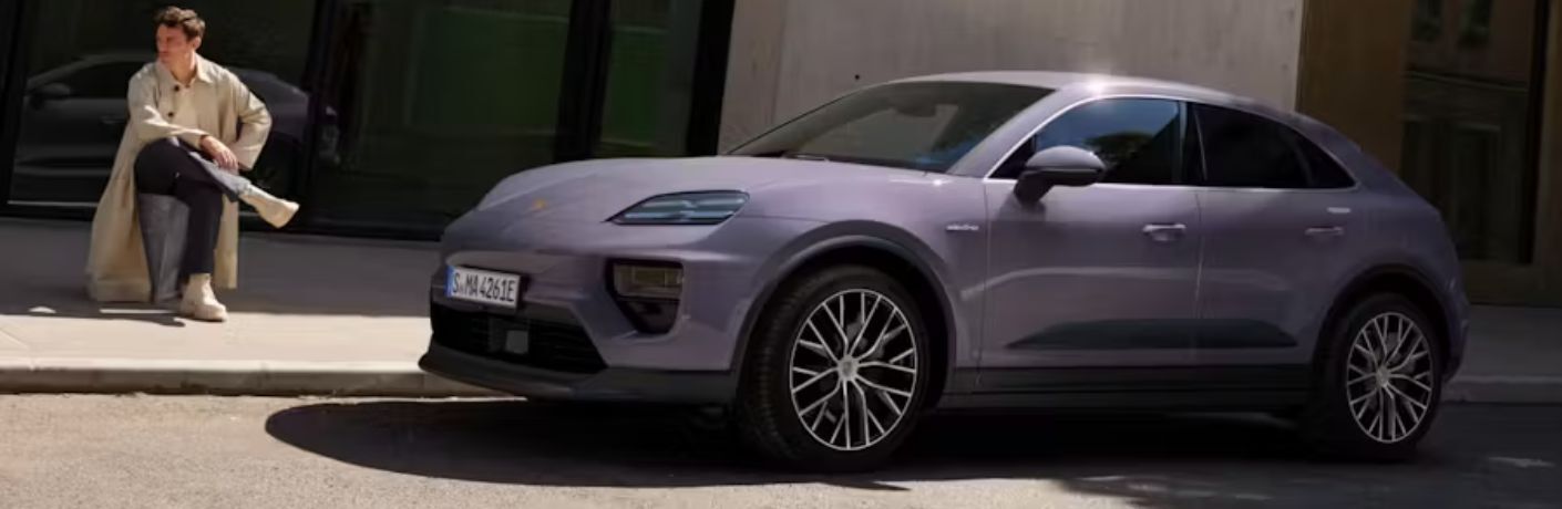 Side View of the 2024 Porsche Macan 4 Electric with a man sitting in the background