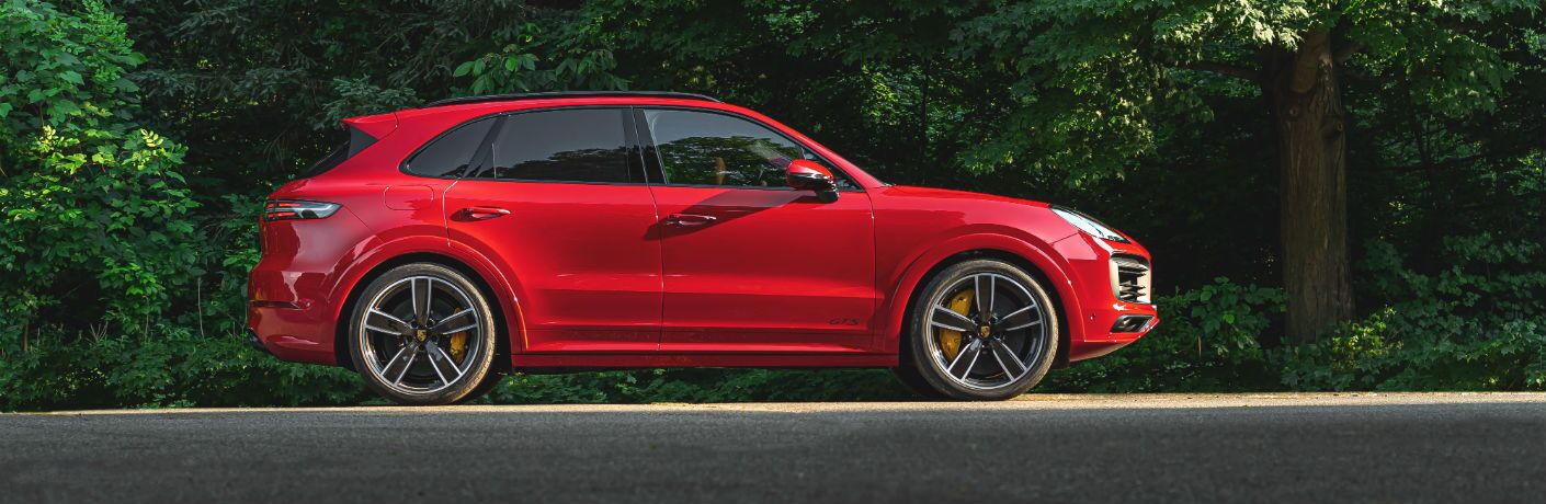 A right profile photo of the 2021 Porsche Cayenne GTS parked in the woods.