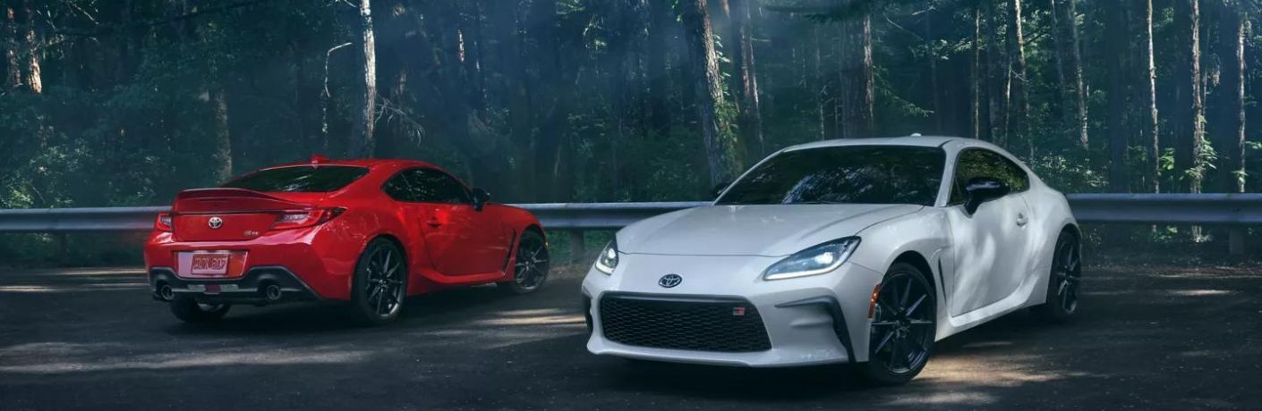 Two 2022 Toyota GR86 models parked on a smooth road