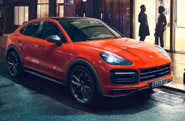 Orange 2020 Porsche Cayenne Coupe on a City Street at Night