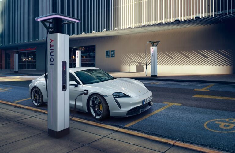 White 2020 Porsche Taycan Charging on a City Street