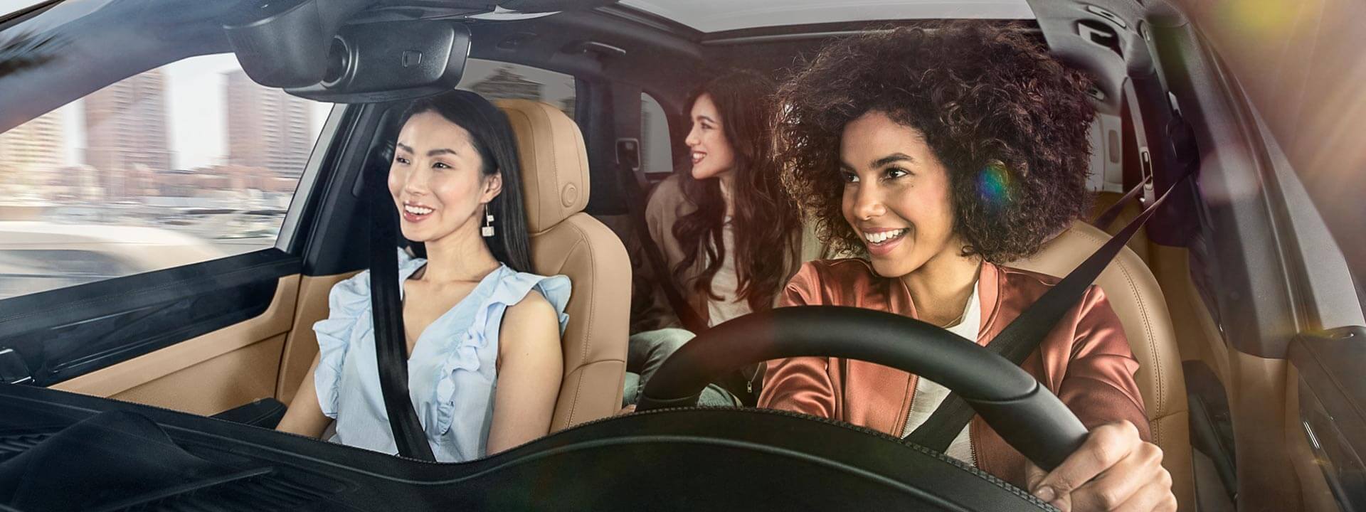 Group of happy women driving in a Porsche in