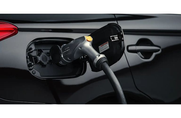 2020 Mitsubishi Outlander PHEV close up of fueling door open and plugged in black paint