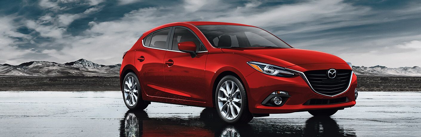 2016 Mazda3 red parked on wet pavement