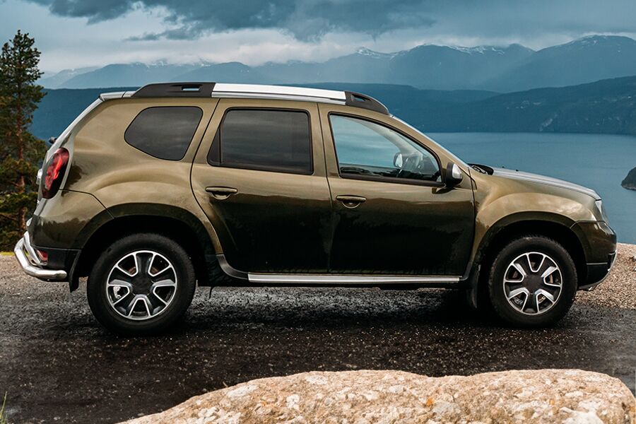 Bronze SUV on mountain top with scenic lake viw