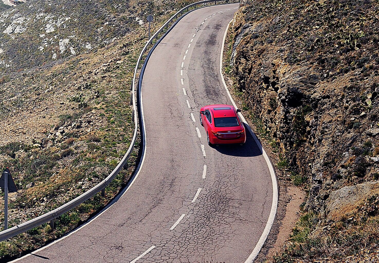 Arial view of soul red Mazda6 on a long road