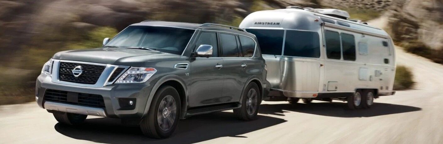Front driver angle of a gray 2019 Nissan Armada pulling a trailer