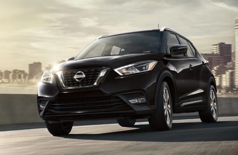 Front driver angle of a black 2019 Nissan Kicks driving down a road