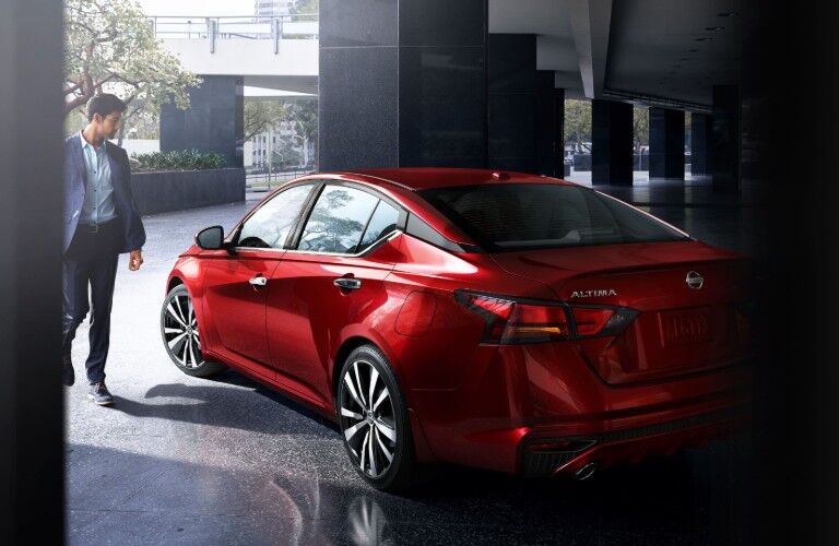 Rear driver angle of the 2020 Nissan Altima with a man walking to it