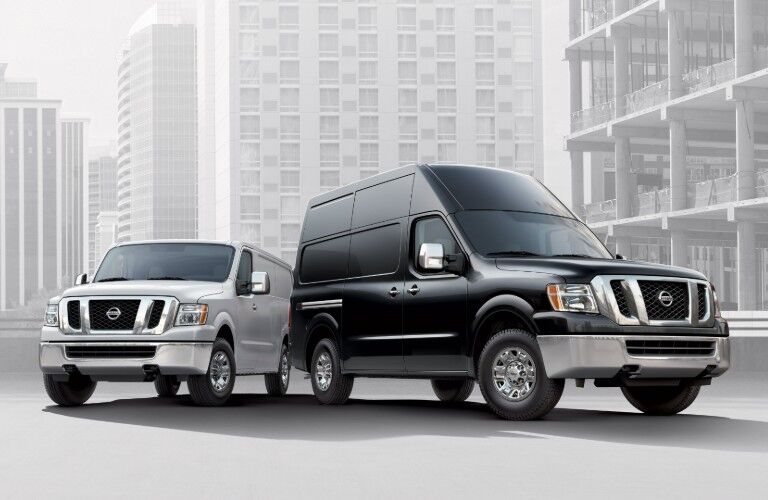 A black and a white 2020 Nissan NV Cargo parked next to each other on a white and grey background